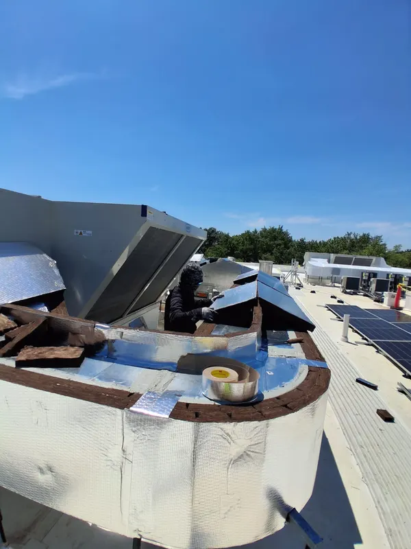 Insulation demolition at a rooftop curb, old material removed