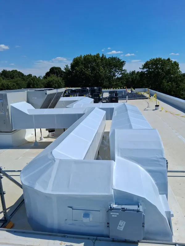 Long insulated duct run crossing a commercial roof
