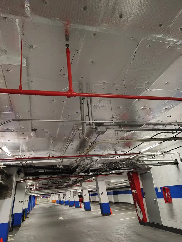 Parking garage ceiling finished in foil faced insulation over the fire lines