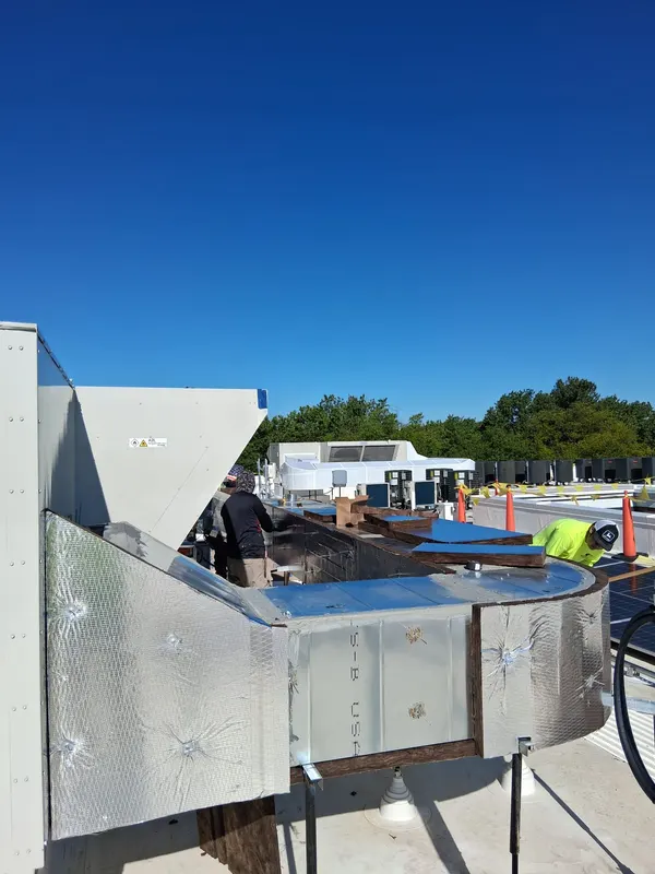 Curved metal jacketing formed around rooftop ductwork