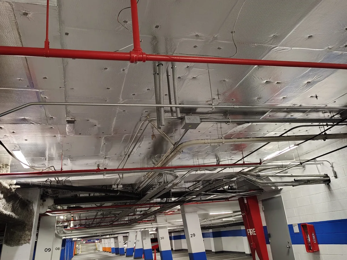 Foil faced insulation across a parking garage ceiling over the fire lines